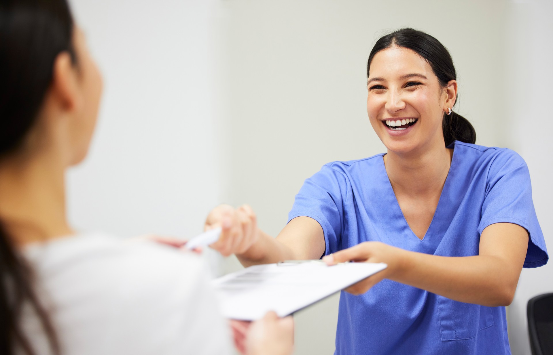 Shot of a patient and assistant interacting in a dentist office